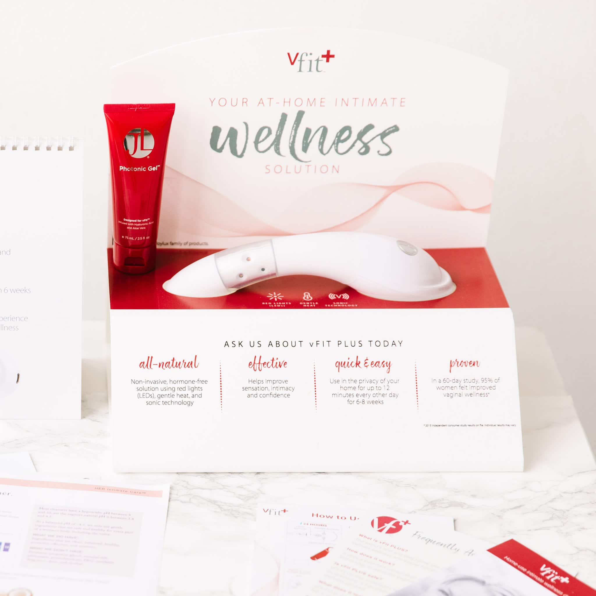 Joylux’s vFit PLUS product for intimate wellness on display with a red bottle of the Photonic Gel alongside it.